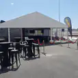 A spacious framed marquee, measuring 8m x 21m, set up with tables and chairs.