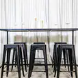A black rectangular tapas table with stools underneath it
