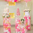 A pink and white birthday party with balloons and Clear Acrylic Round Plinth Hire - Set of 3.