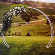 A bridal arch adorned with flowers in the middle of a field.