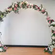 Bridal Arch Hire adorned with white and pink flowers.