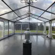 A clear tent with a chandelier in the middle, enhanced with Pkg 7 - 7 x Area Heater Hire w/ Gas Bottles.