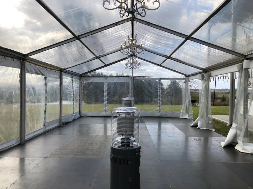 A clear tent with a chandelier in the middle, enhanced with Pkg 7 - 7 x Area Heater Hire w/ Gas Bottles.