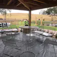 A patio with a view of a pond, featuring a table and chairs.