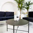Black Cross Coffee Table next to velvet blue lounges