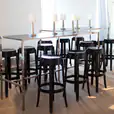 Black Ghost bar stools in the middle of a room available for hire.