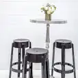 Three black Ghost stools on a white table.