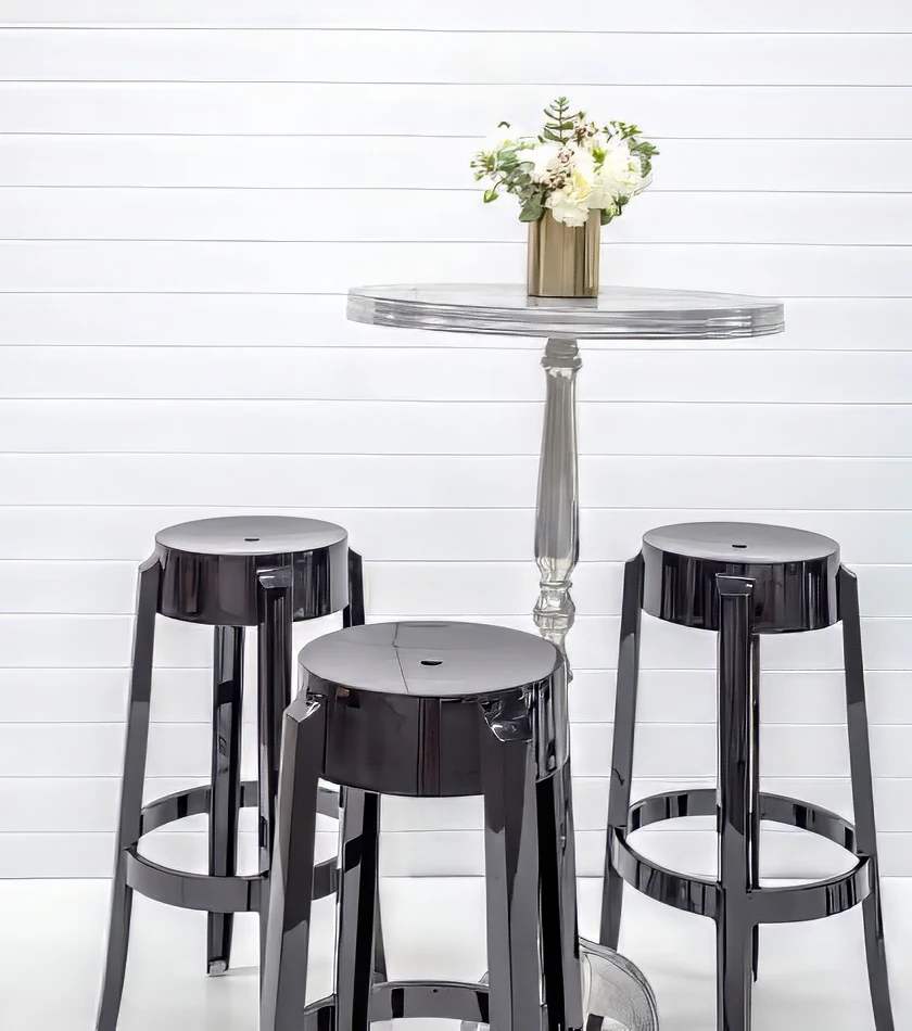 Three black Ghost stools on a white table.