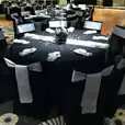 A black and silver banquet table adorned with elegant silver bows.