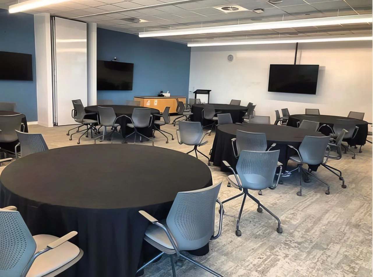 A conference room set up with black round banquet tablecloth hire.