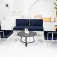 Black round coffee table in the middle of the lounge setting