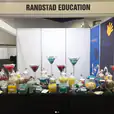 Randstad education showcased their booth at a trade show featuring a black tablecloth for their standard trestle table.