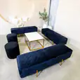 Black velvet ottoman benches around a coffee table