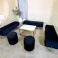 Black velvet ottoman stools next to an Ottoman lounge