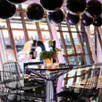 A table with black balloons in the middle of a room, enhanced by a Black Wire Stool.