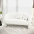 A white bouclé 2-seater sofa in front of a window.
