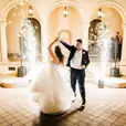 A bride and groom dancing with dry sparklers in front of an archway.
