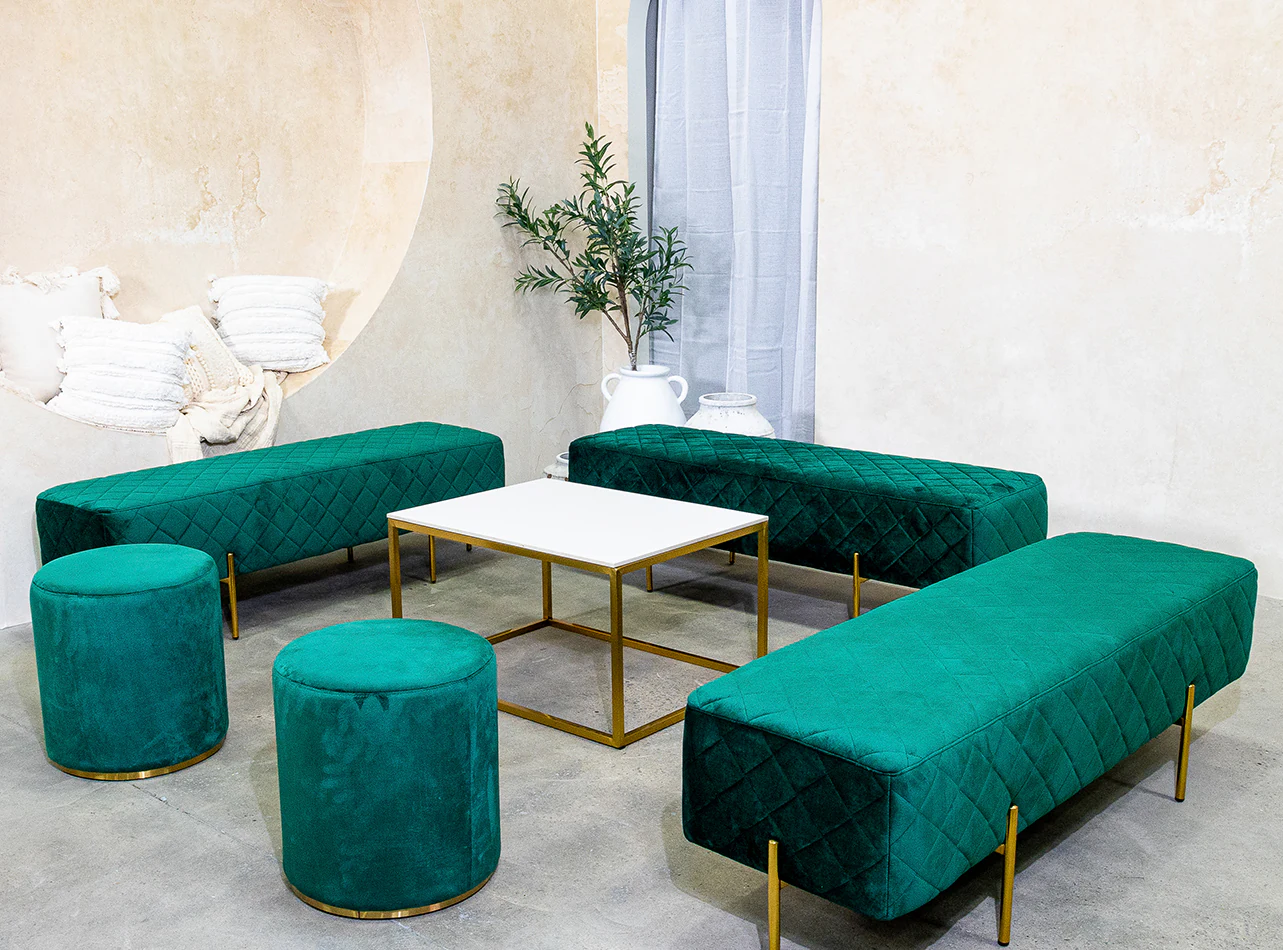 Emerald green velvet ottoman benches around a coffee table