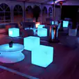 A group of colorful LED glow cubes on a wooden deck for hire.