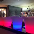 A group of lighted stools in a bar, creating a glowing ambiance.