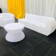 A white couch and a white coffee table in a room.