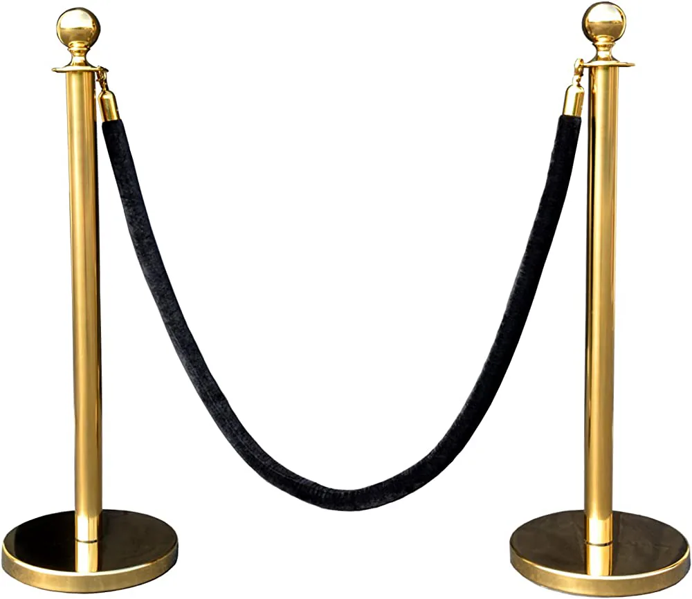 A pair of gold bollards hire with black ropes.