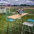 A High Bar Table with a Timber Top and chairs at a race track.