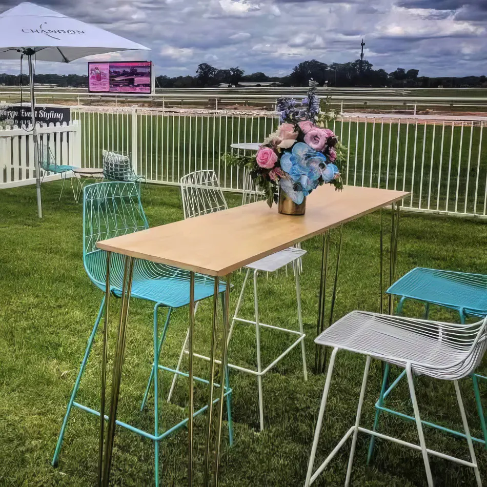 A High Bar Table with a Timber Top and chairs at a race track.