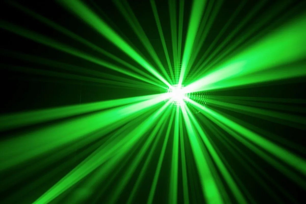 A mesmerizing image of a vibrant green laser light illuminating a captivating black background.