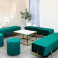 Green velvet ottoman stools next to an ottoman lounge