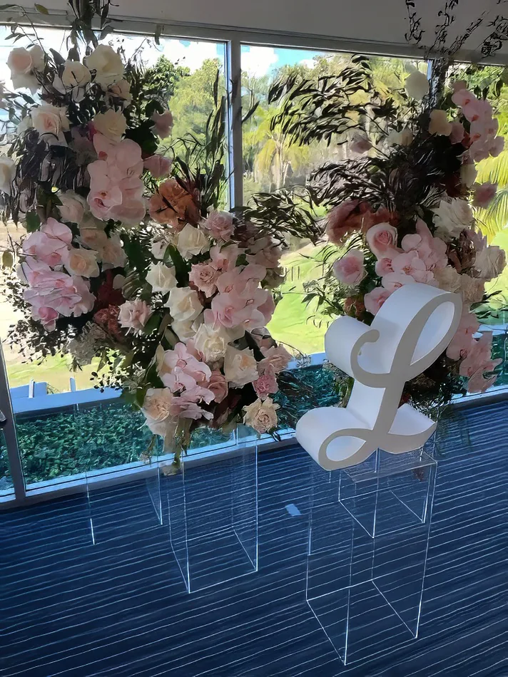 Clear acrylic plinths displaying florals at a styled event