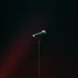 A wireless microphone in front of a dark background.