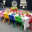 A table set up for a birthday party with balloons and kids chair hire.