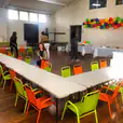 A whimsical room filled with colorful tables and chairs adorned with vibrant balloons.