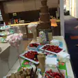 A chocolate bar with strawberries, marshmallows, and other desserts on a table.
