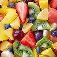 A vibrant display of medium-sized fruit platter, showcasing in-season fruits, presented in a bowl.