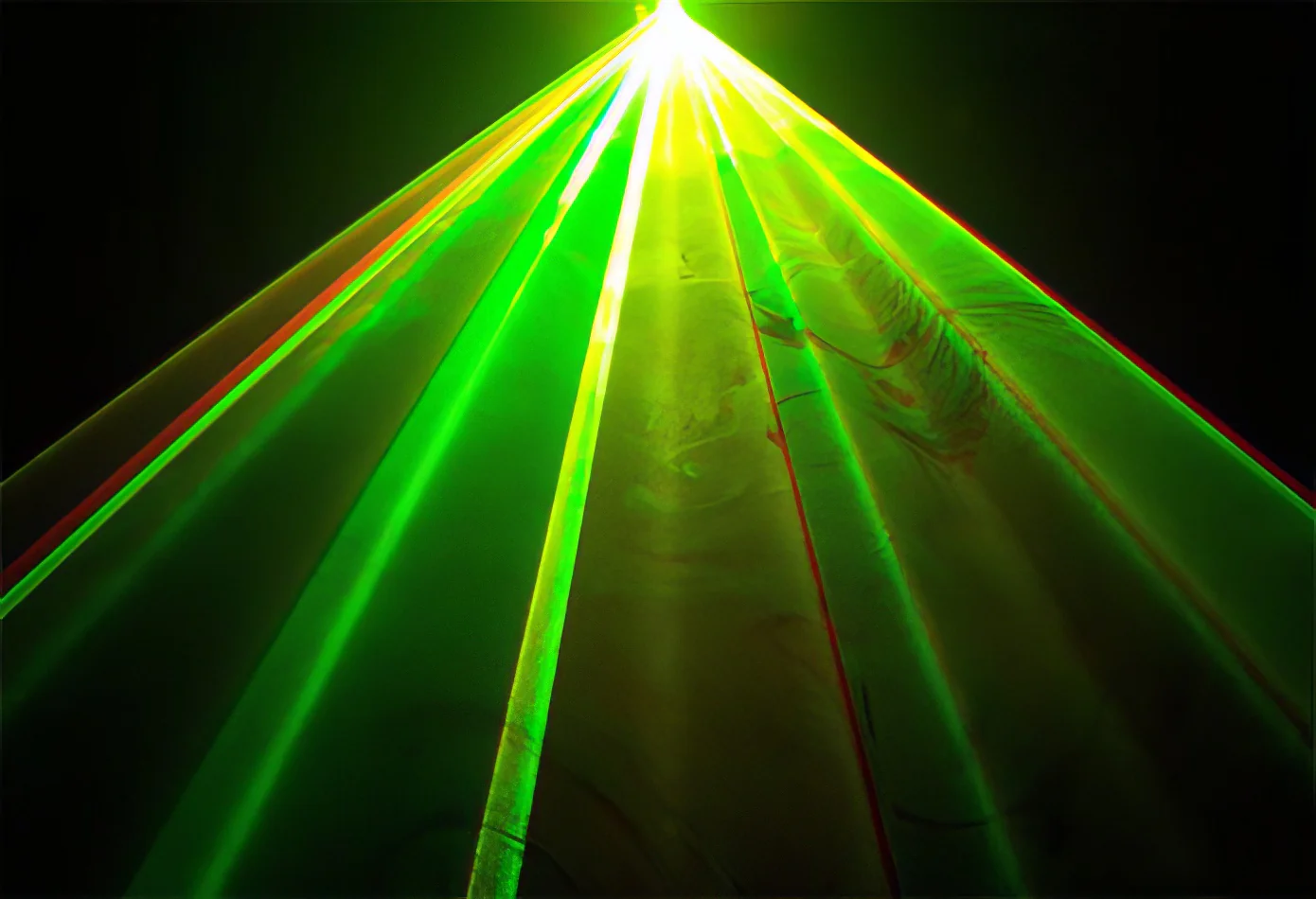 An image of a green laser light cutting through the darkness.