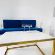 Navy blue wire sofa lounge behind a coffee table