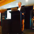 Two people standing at a lectern at an event.