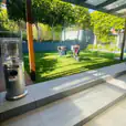 A backyard with a patio, fire pit, and Pkg 8 - 8 x Area Heater Hire w/ Gas Bottles for added warmth and ambiance.