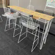 A white hairpin high bar table with timber top in an office.