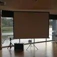 A spacious room featuring a projector screen on one side.