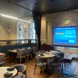 A room with tables and chairs, suitable for projector screen hire (2m wide x 1.5m tall).