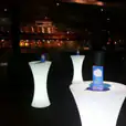Glow cocktail bar tables hire in a dark room.