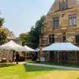 A 3mx6m pop up marquee with a white roof is set up in front of a stone building.