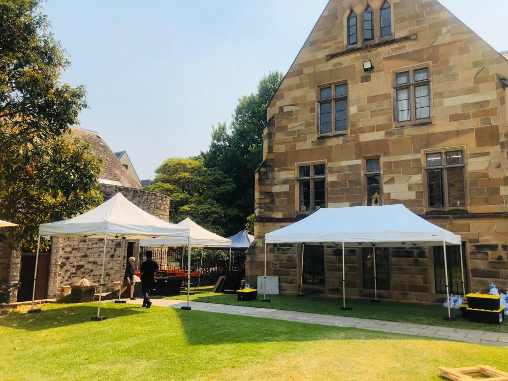 A 3mx6m pop up marquee with a white roof is set up in front of a stone building.