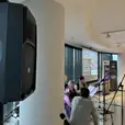 A group of people in a room with a speaker hired.