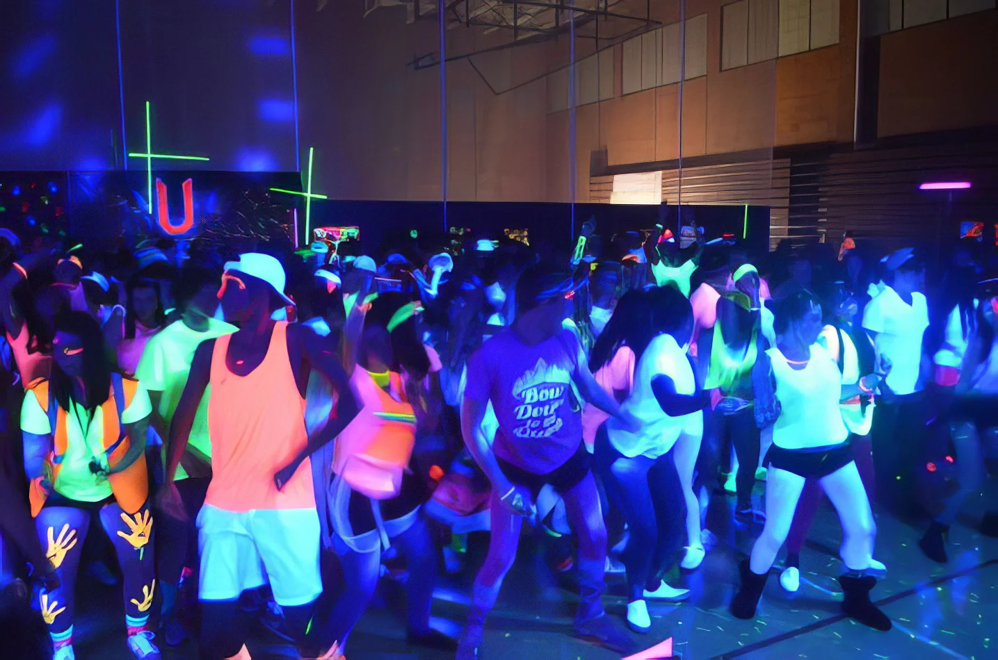 A group of people dancing in a gym with UV Black Light Hire, creating a stunning neon-lit atmosphere.