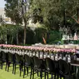A table adorned with black chairs and pink flowers.