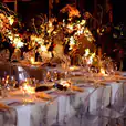 A dinner table set up with candles, flowers, and Victorian Ghost Chair Hire.